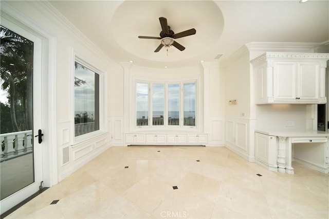 interior space with a raised ceiling and ceiling fan