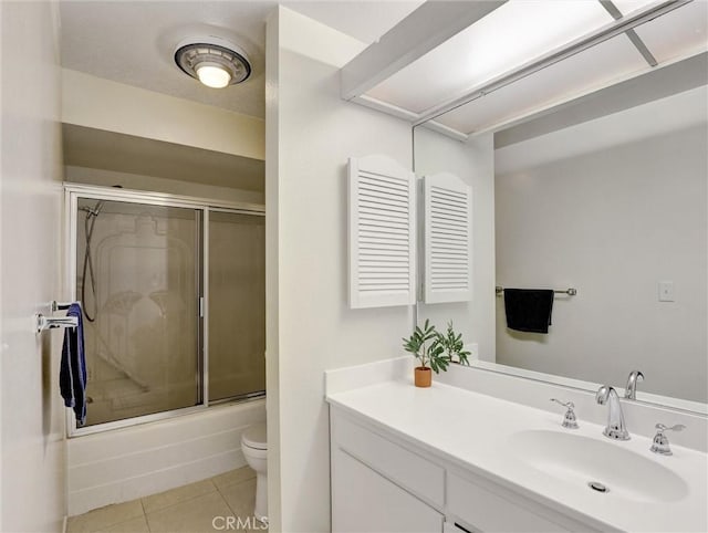 bathroom featuring toilet, shower / bath combination with glass door, vanity, and tile patterned floors