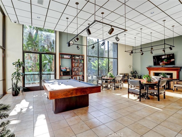 game room with a wall of windows, light tile patterned flooring, billiards, and track lighting