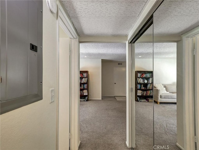 corridor with a textured ceiling, carpet floors, electric panel, and baseboards