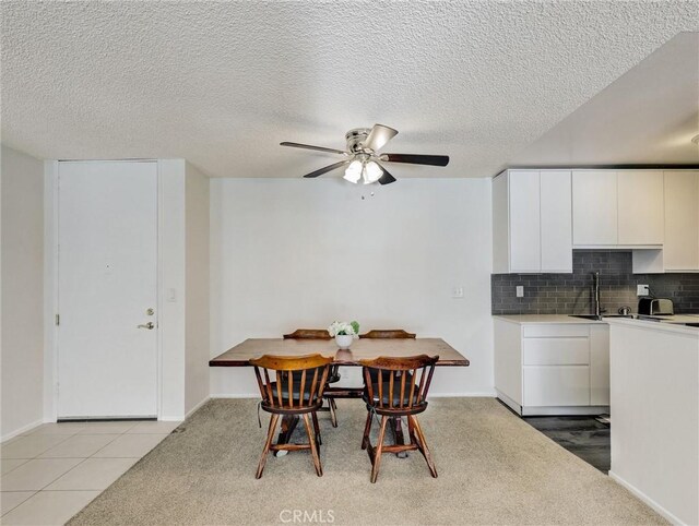 tiled dining room with ceiling fan and sink