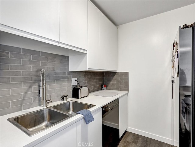 kitchen featuring black dishwasher, light countertops, freestanding refrigerator, white cabinets, and a sink