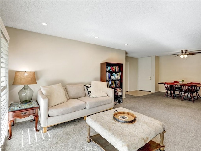 living room featuring a textured ceiling, ceiling fan, carpet flooring, and recessed lighting