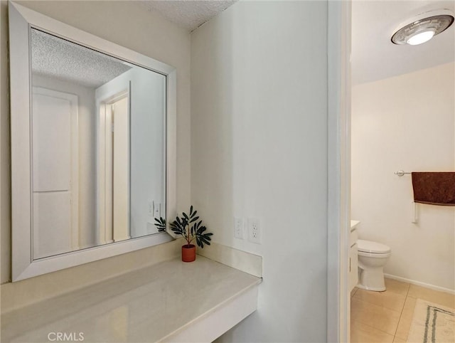 bathroom featuring toilet, tile patterned floors, a textured ceiling, and vanity