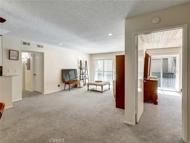 carpeted living room featuring a textured ceiling