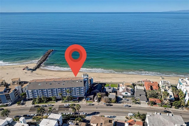 birds eye view of property featuring a water view and a beach view