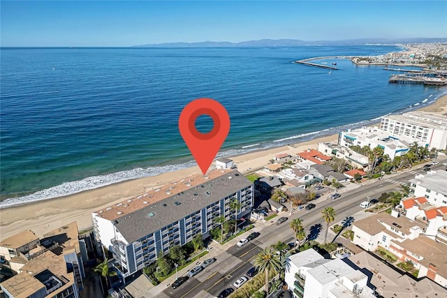 drone / aerial view with a water view and a beach view