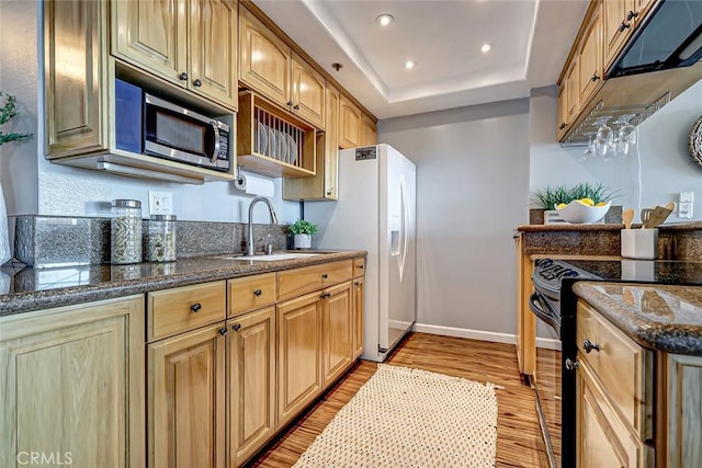 kitchen with white refrigerator with ice dispenser, black electric range, sink, dark stone counters, and a tray ceiling