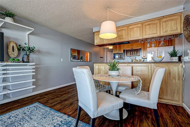 dining area with dark wood-type flooring and a textured ceiling