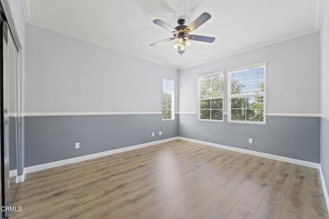 empty room featuring light wood-type flooring, ceiling fan, a wealth of natural light, and crown molding