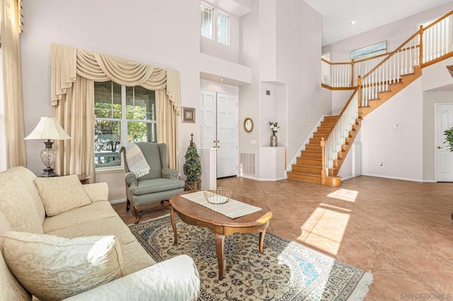 living room featuring a healthy amount of sunlight and a towering ceiling