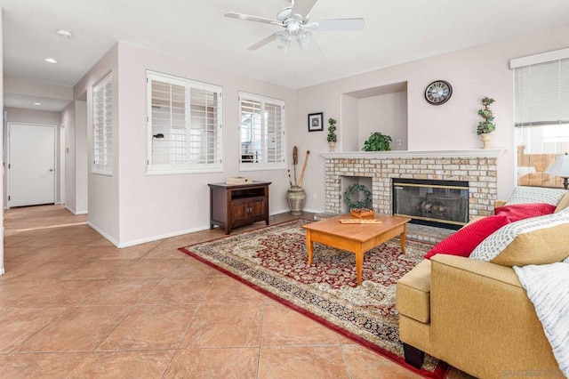 tiled living room featuring a brick fireplace and ceiling fan