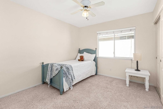 carpeted bedroom with ceiling fan and a closet