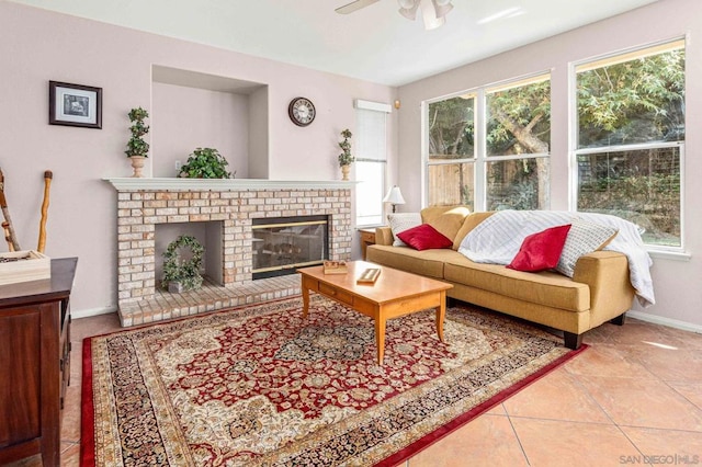 tiled living room with a brick fireplace and ceiling fan