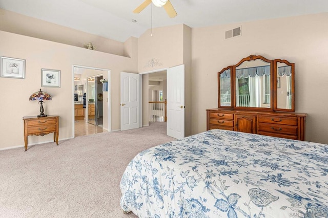 carpeted bedroom featuring vaulted ceiling, ensuite bath, and ceiling fan