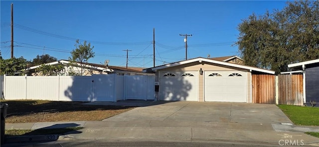 garage with fence and driveway