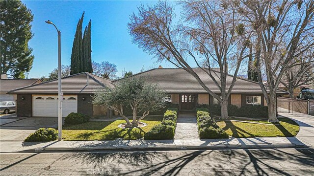 ranch-style house with a front yard and a garage