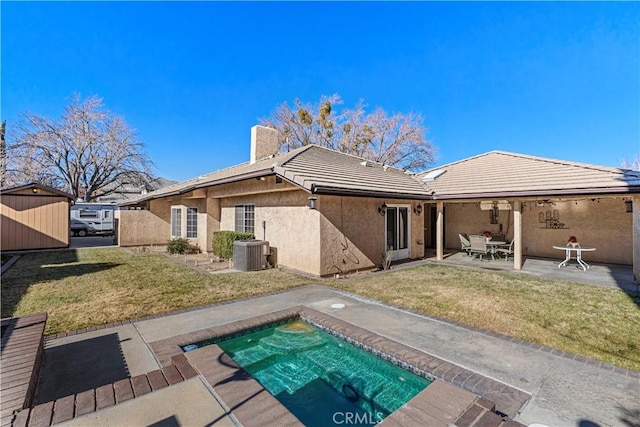 rear view of house featuring a yard, a patio, and cooling unit