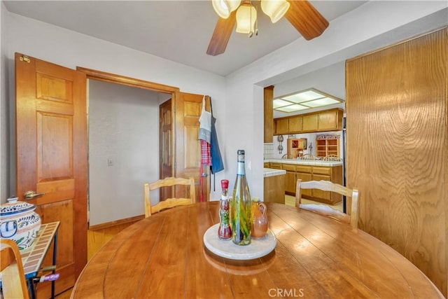 dining space featuring ceiling fan and wood walls