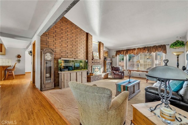 living room featuring light wood-type flooring, vaulted ceiling, and a fireplace