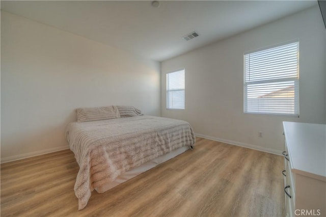 bedroom with light hardwood / wood-style flooring and multiple windows