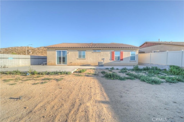 back of property with central air condition unit and a patio area