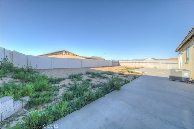 view of yard with central air condition unit and a patio area