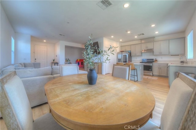 dining room featuring sink and light hardwood / wood-style flooring