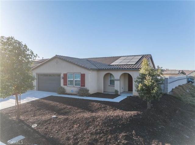 view of front of home featuring solar panels and a garage