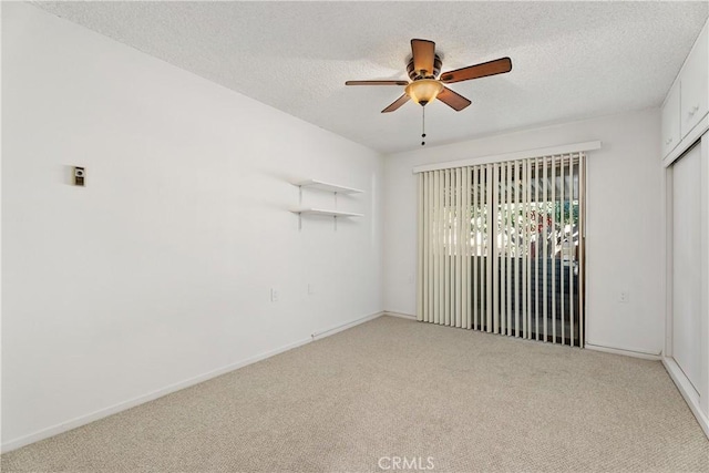 carpeted spare room with ceiling fan and a textured ceiling