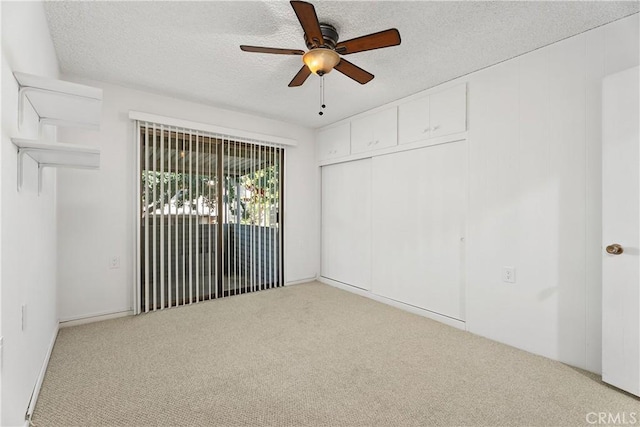 unfurnished room with ceiling fan, light colored carpet, and a textured ceiling