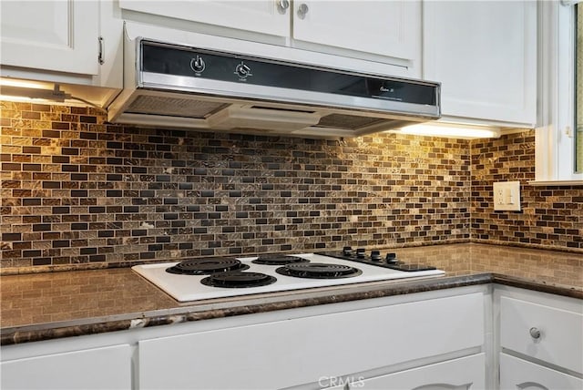 kitchen featuring white electric cooktop, exhaust hood, backsplash, and white cabinetry