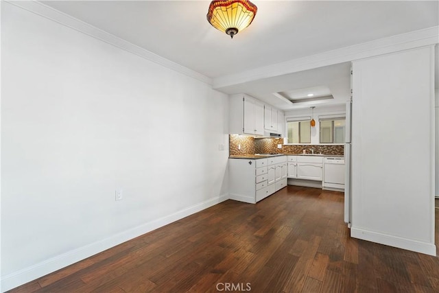 kitchen with dishwasher, a raised ceiling, dark hardwood / wood-style floors, white cabinetry, and backsplash