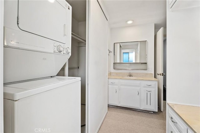 clothes washing area featuring sink, stacked washer / dryer, and light colored carpet