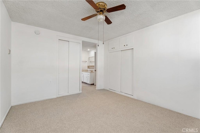 empty room featuring a textured ceiling, ceiling fan, and light colored carpet