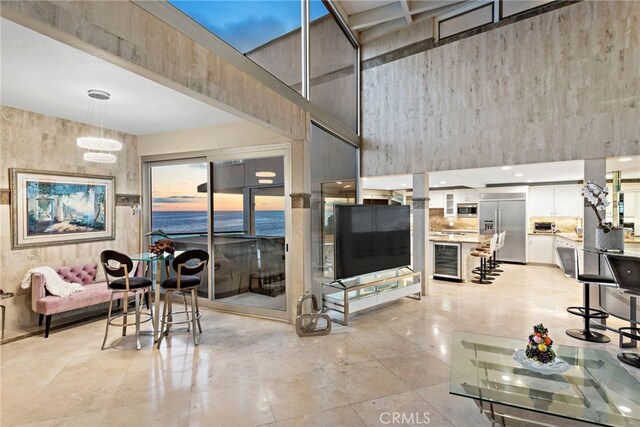 living room featuring a high ceiling and beverage cooler