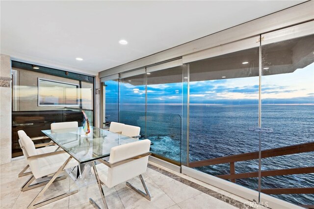 dining space featuring expansive windows, a water view, and tile patterned floors