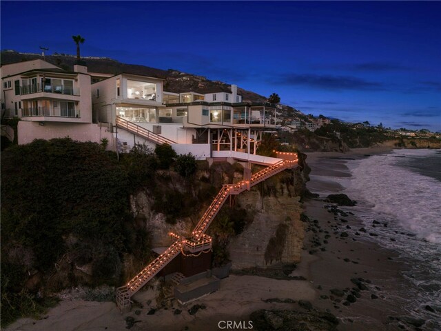 back house at dusk featuring a water view