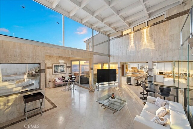 living room featuring coffered ceiling, a towering ceiling, and beam ceiling