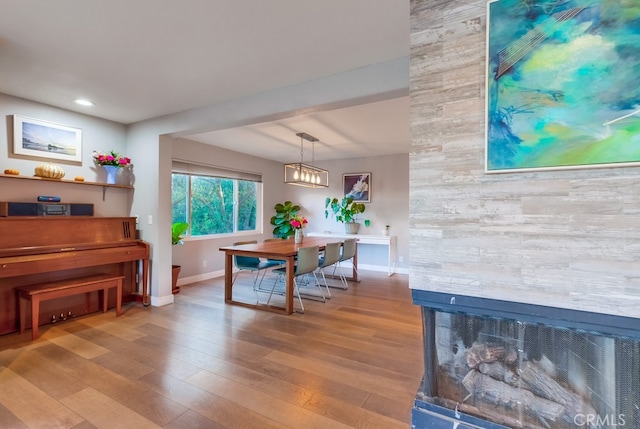 dining area featuring a fireplace and light wood-type flooring