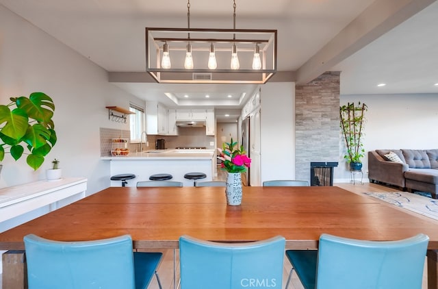 dining space featuring sink and a large fireplace