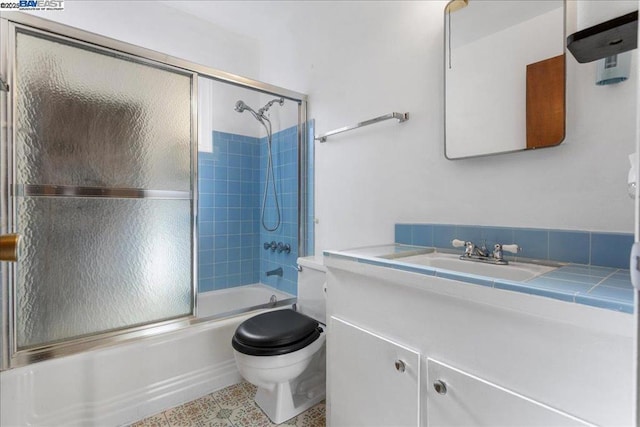 full bathroom with toilet, combined bath / shower with glass door, and vanity