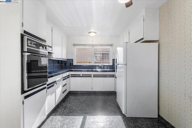 kitchen with sink, white cabinets, black appliances, and decorative backsplash