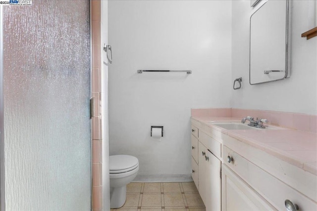 bathroom featuring toilet, an enclosed shower, and vanity