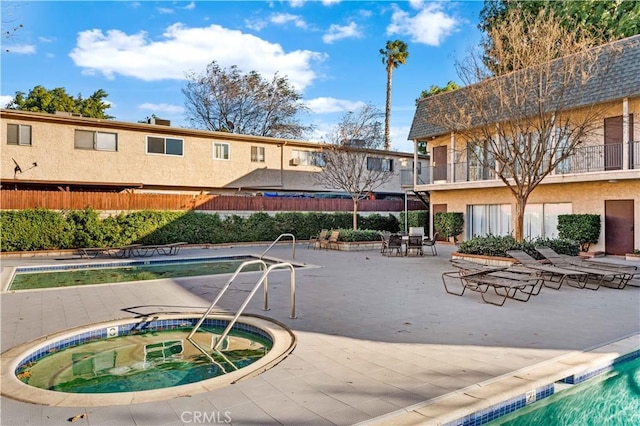 view of pool featuring a community hot tub and a patio