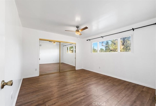 empty room with dark hardwood / wood-style flooring and ceiling fan