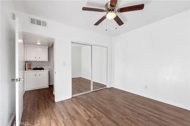 unfurnished bedroom with wood-type flooring, a closet, and ceiling fan