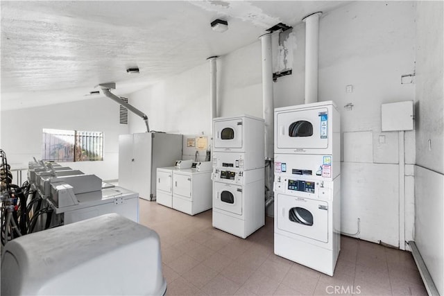 kitchen featuring washer and dryer, stacked washer / drying machine, white cabinetry, and vaulted ceiling