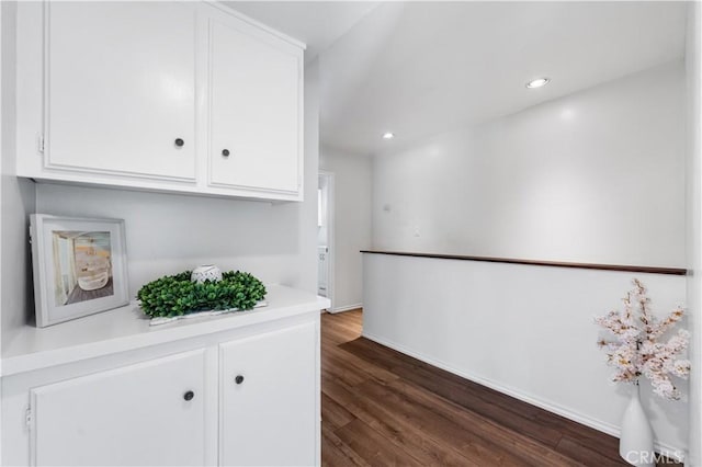 bar with white cabinets and dark hardwood / wood-style floors