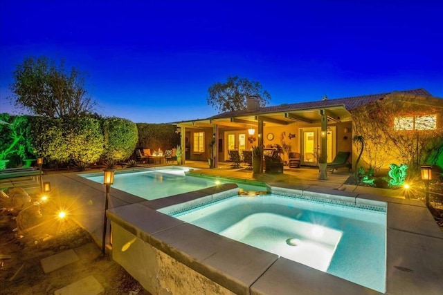 view of pool with a patio area and an in ground hot tub